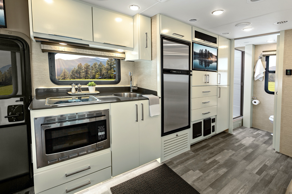 The kitchen inside the new 2020 Tiffin Wayfarer with linen cabinets and reston ivory wall coverings. 