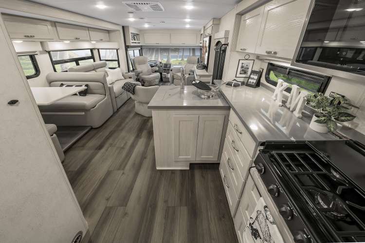 The interior of the 2020 Winnebago Forza in the mineral contemporary option, featuring neutral tones and luxury wood plank flooring. 