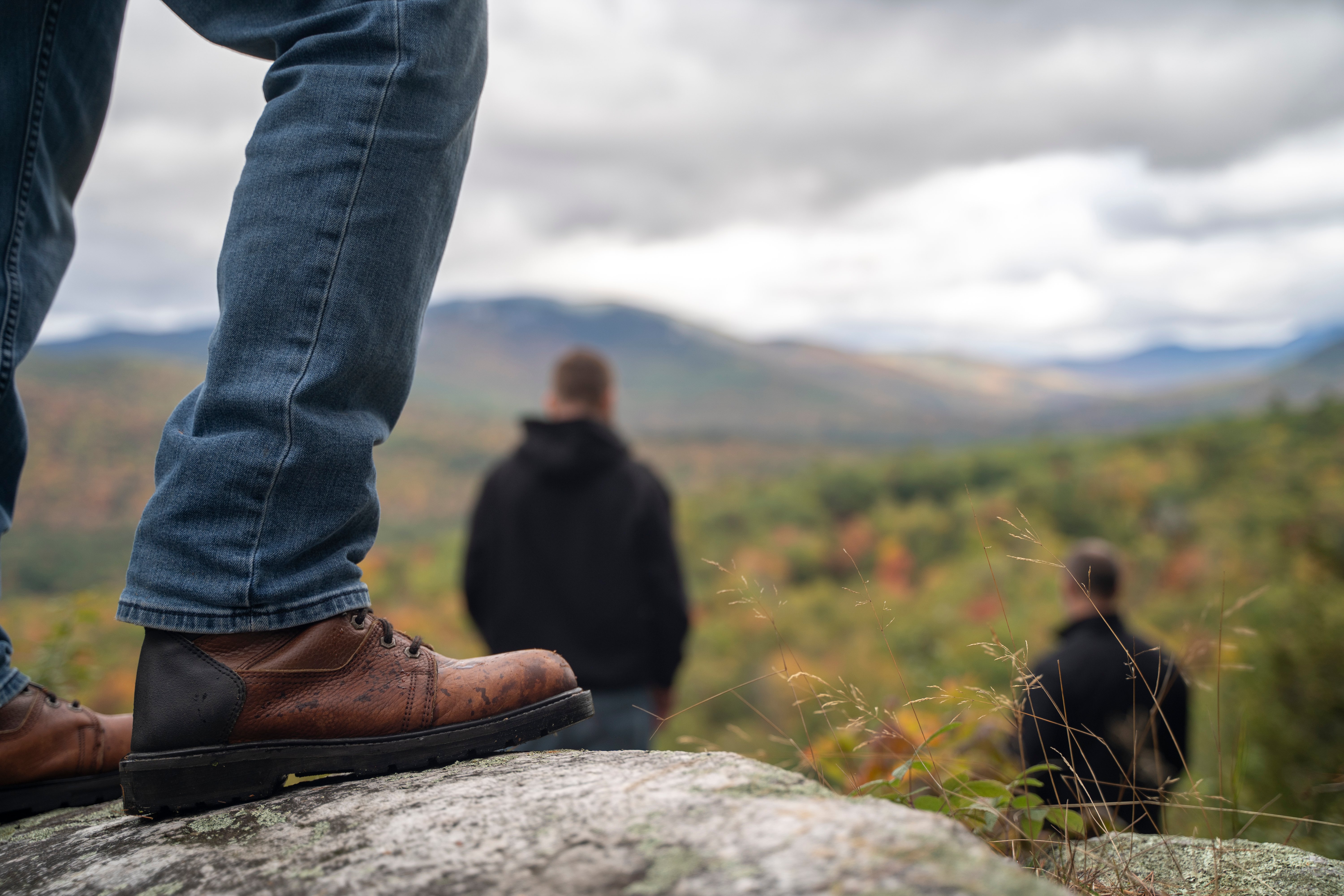 A person standing on the top of a mountain overlooking the fall colors. 