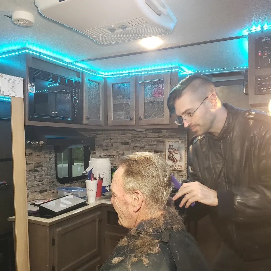 Richard Reed performing men's haircut in the mobile RV hair salon