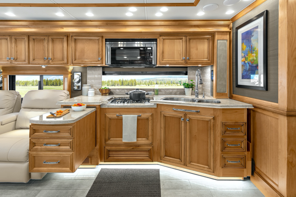 The interior of the 2020 Tiffin Phaeton’s kitchen in amber glazed and trend beige. 