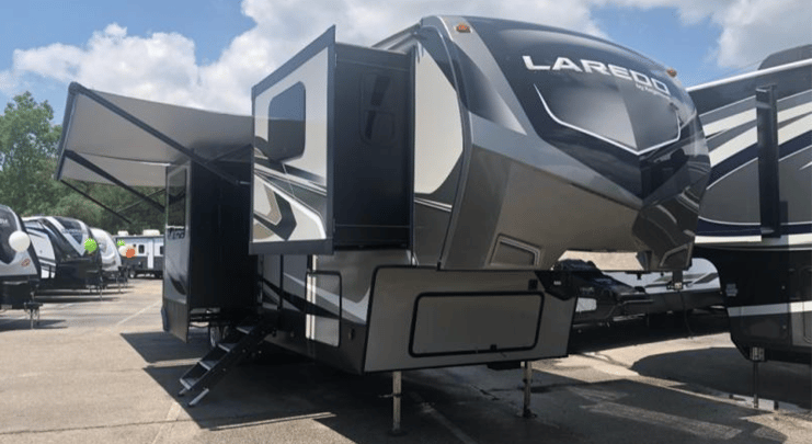 The exterior of the 2020 Keystone Laredo 353FL Fifth Wheel featuring four slideouts and a power adjustable awning. 