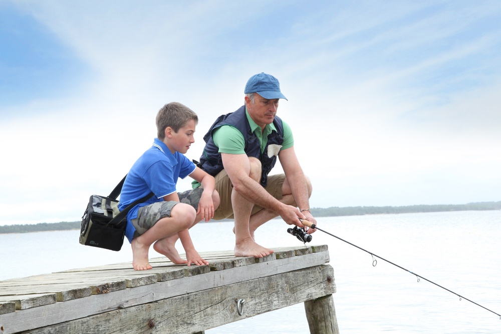 Father and son fishing in lake