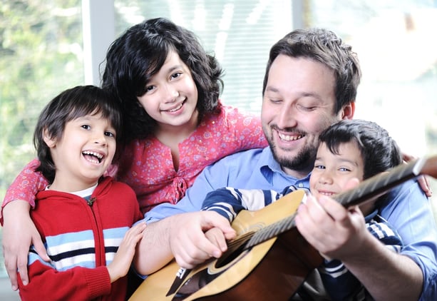 Happy family playing guitar together at home.jpeg