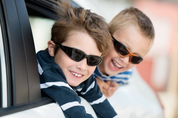 Two little boys with shades playing inside the car.jpeg