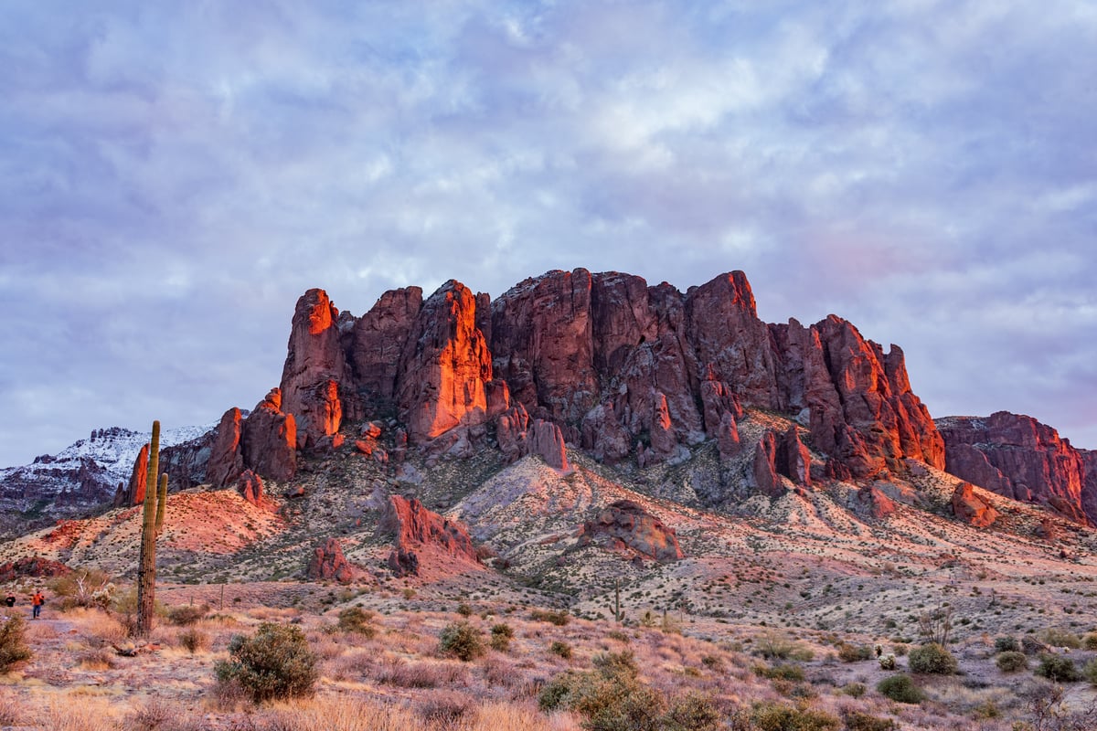 Photo of the Superstition Mountains in Arizona with sunset and snowcaps in background