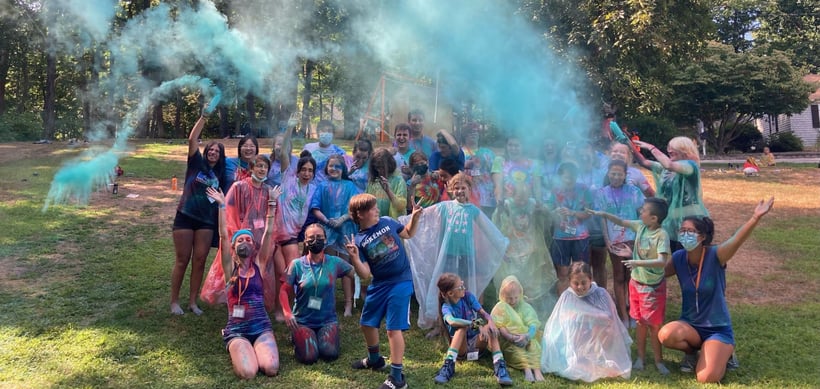 campers_toss_colorful_dust_into_the_air_in_group_photo