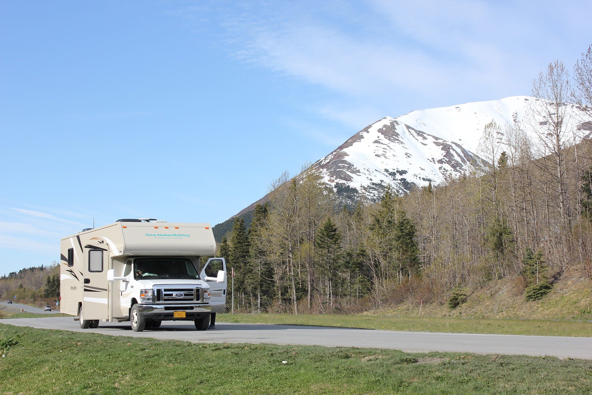 class c motorhome driving past mountains