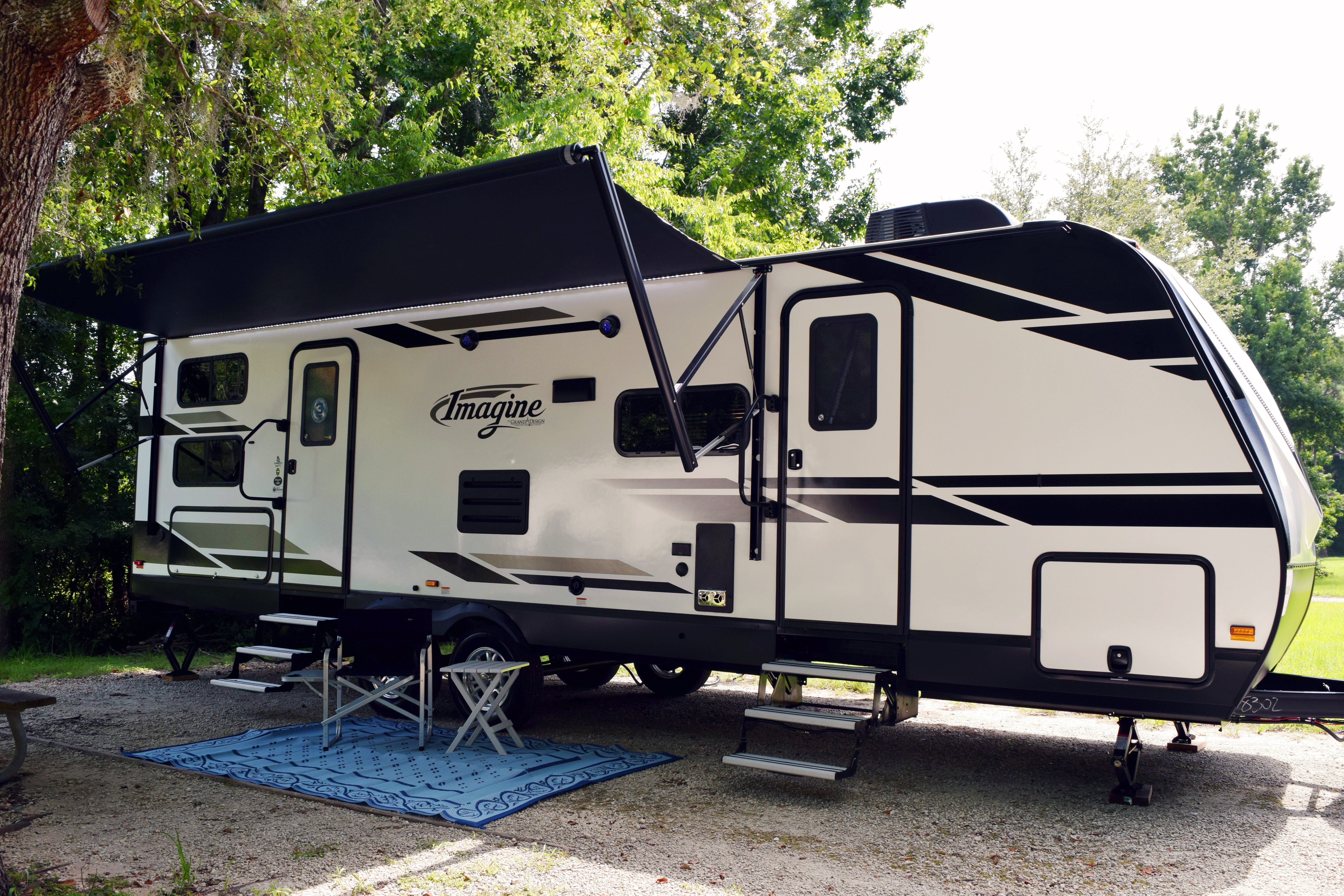 grand design travel trailer imagine set up at a campsite