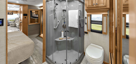 : A Class A Tiffin Phaeton motorhome, featuring a walk-in glass shower and double entry bathroom.