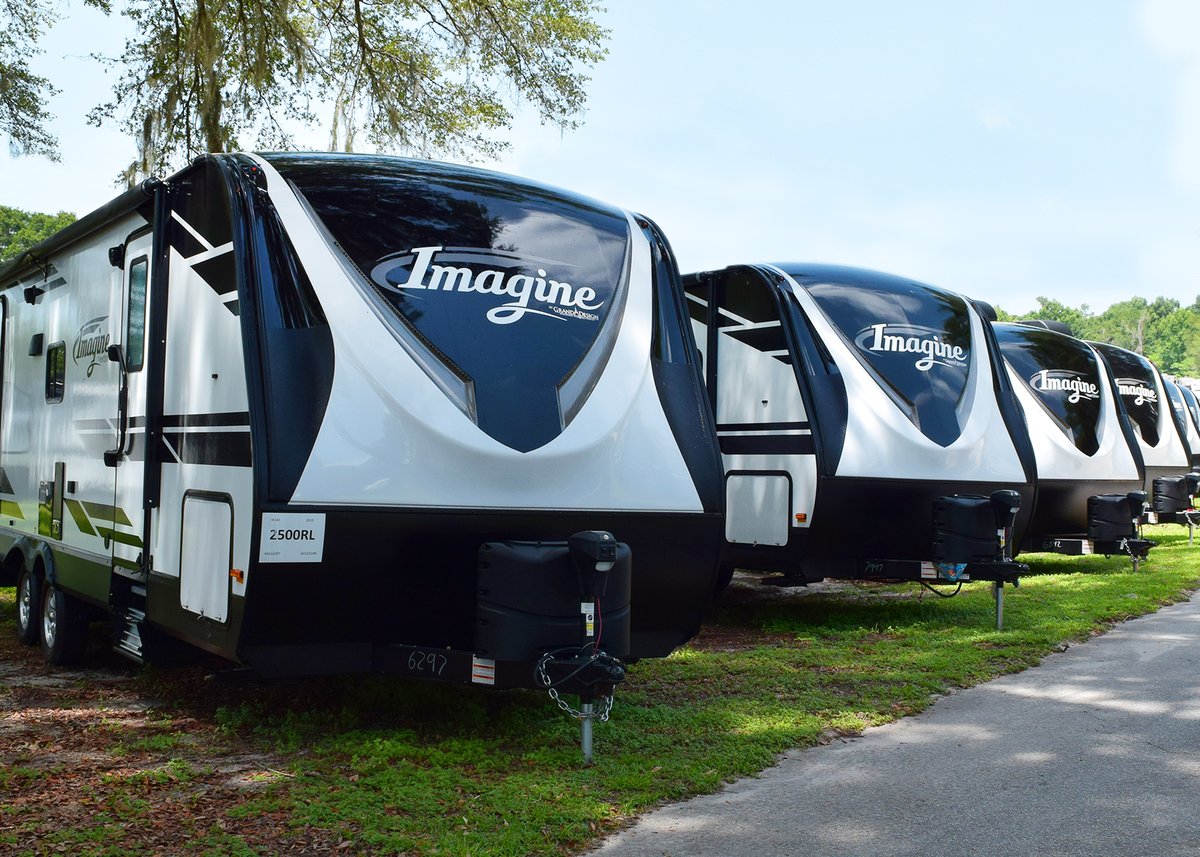 a line up of grand design imagine travel trailers