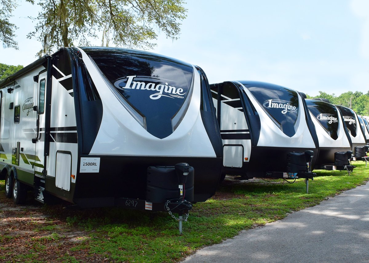 grand design imagine travel trailer lined up on a dealership lot