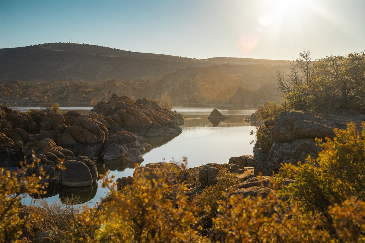 Watson Lake in Prescott Arizona with sun and granite dells in the background