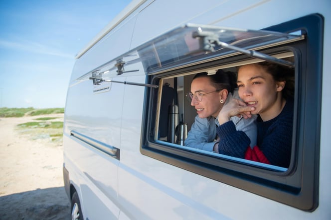 Two women look through the kitchen window of the RV