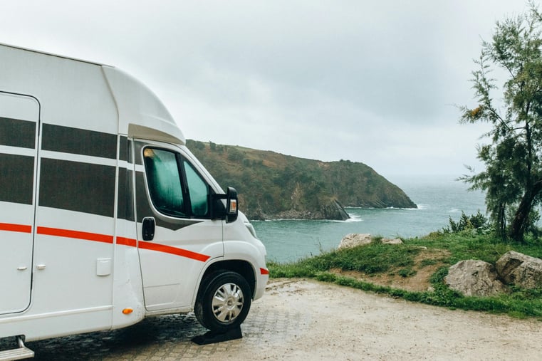 Class B RV parked in a parking lot on a cliffside overlooking the ocean