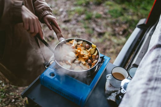 People frying potatoes on a small outdoor cooktop