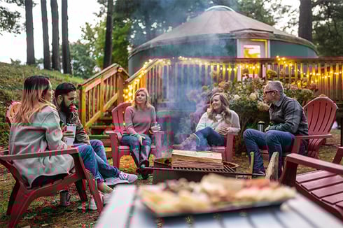 A group of friends sit around a campfire